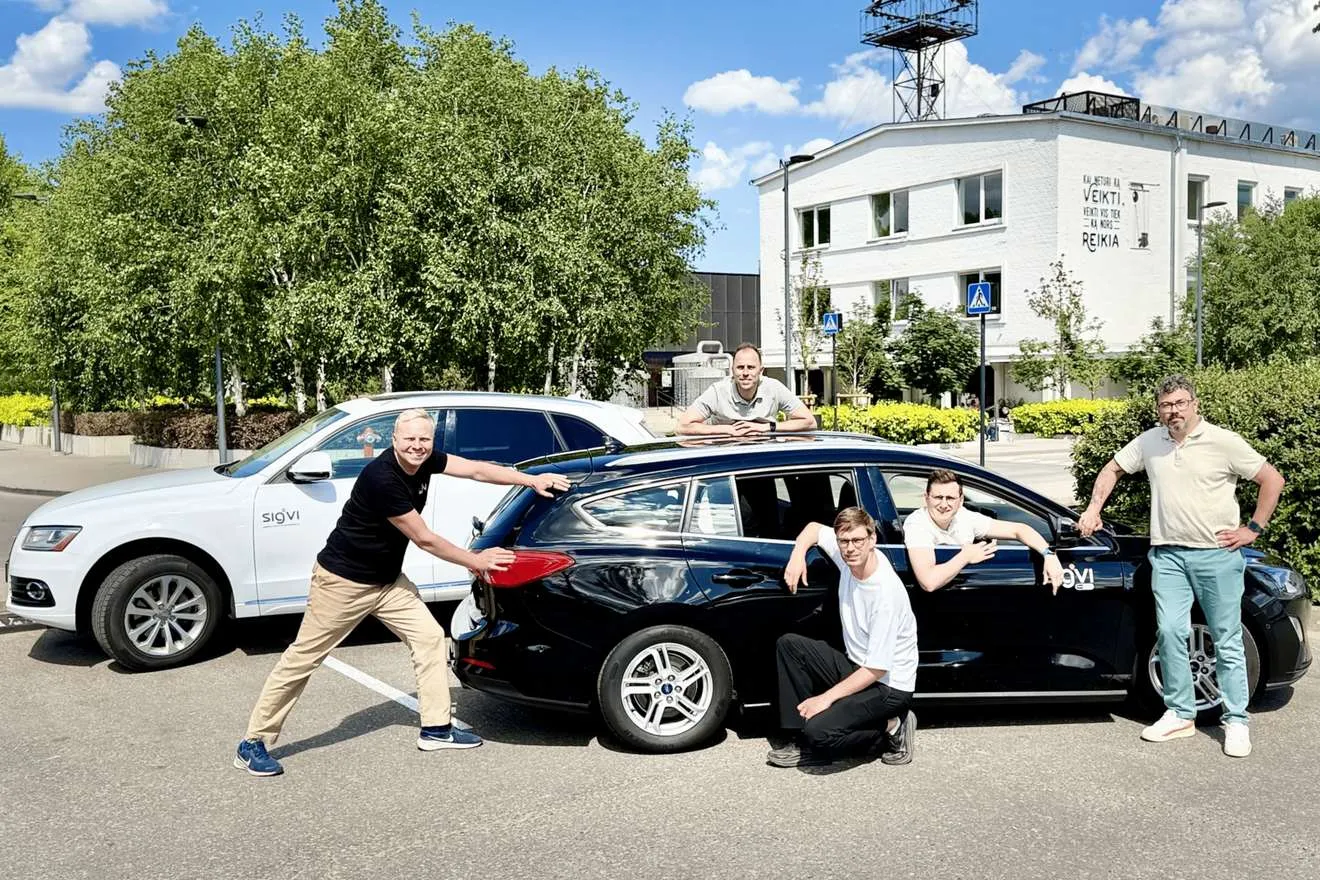 Five members of the Sigvi team posing around two Sigvi cars in a car park